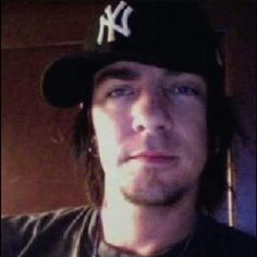 a man with long hair wearing a baseball cap