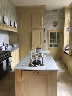 a large kitchen with an island in the middle and two candles on top of it