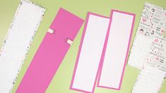 several pieces of paper are laid out on a green surface with pink and white strips