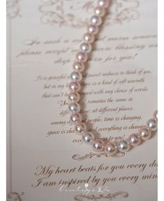 a pearl necklace on top of an open letter