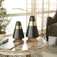 three black and gold cone lamps sitting on top of a coffee table in a living room