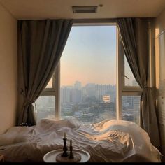 a bedroom with a large window overlooking the city