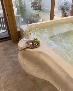 a bowl of fruit sitting on top of a table next to a jacuzzi tub