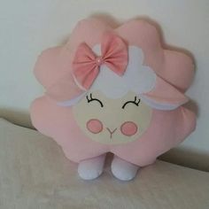 a pink stuffed animal with a bow on it's head sitting on a bed