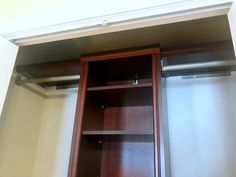 an empty closet with wooden shelves and sliding doors