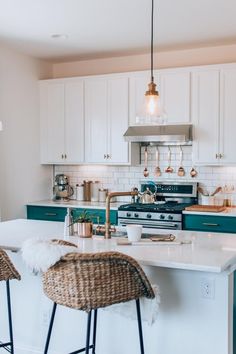 a kitchen with two bar stools next to an island in front of the stove