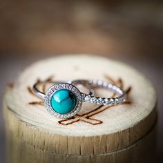 two rings sitting on top of a piece of wood next to each other with diamonds around them