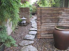 a garden with rocks, plants and a water fountain