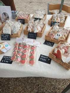 several baskets filled with food on top of a white table cloth covered table next to a wooden chair