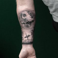 a man's arm with a black and white tattoo design on the left forearm