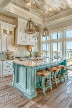 a large kitchen with an island in the middle and two stools at the end