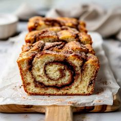 cinnamon roll sitting on top of a wooden cutting board