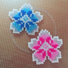 two pieces of plastic bead art sitting on top of a table