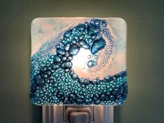 a light that is on the side of a wall with some water bubbles in it