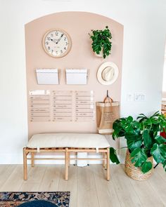 a living room with a bench, plant and clock on the wall next to it