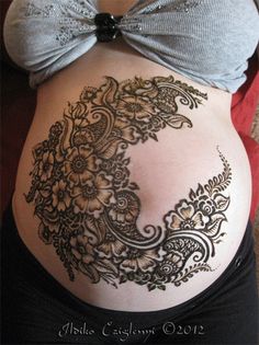 a pregnant woman's belly with an intricate design on it