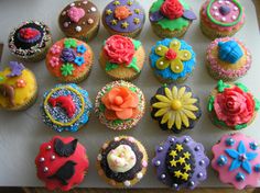 there are many decorated cupcakes on the table