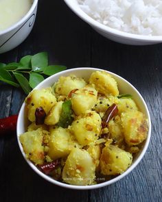 two bowls filled with food next to white rice and green leafy garnish