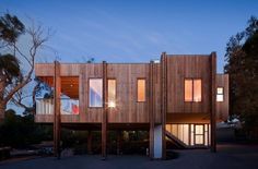 the building is made out of wood and has multiple windows on each side, along with two balconies