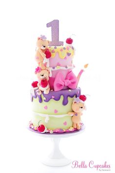 a birthday cake decorated with teddy bears and a number one on it's top