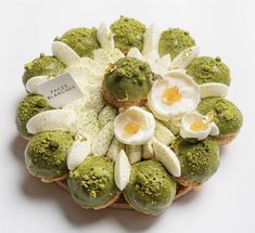 a plate filled with cookies covered in green and white icing next to an egg