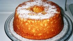 a cake sitting on top of a glass plate covered in powdered sugar and sprinkled with icing