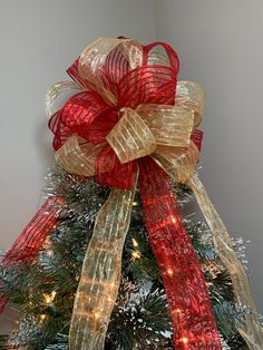 a decorated christmas tree with red and gold ribbons