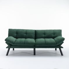 a green couch sitting on top of a white floor