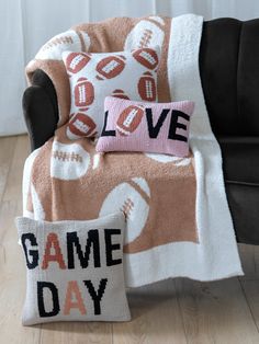 a game day blanket and pillow on a couch with the word love written across it