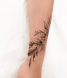 a woman's foot with a flower tattoo on her left side and the bottom part of her leg