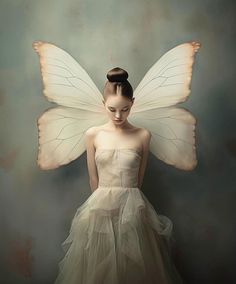 a woman in a white dress with a butterfly wings on her head, standing against a wall