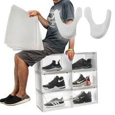 a man sitting on top of a display case with shoes in the bottom shelf and one shoe hanging from it's side