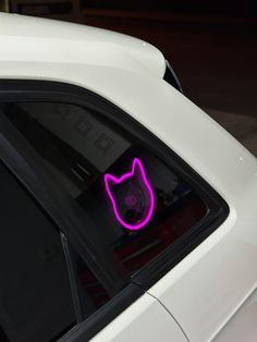 a car with a cat head on it's side window sticker in the dark