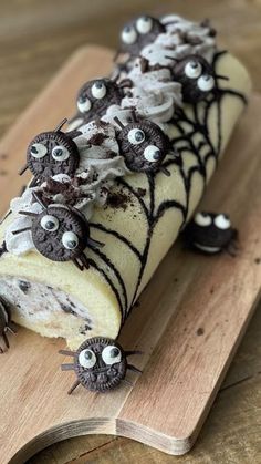 a piece of cake with chocolate spooks and spider web decorations on it, sitting on top of a wooden cutting board