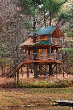 a tree house in the middle of a wooded area with water and trees around it