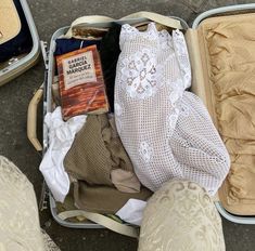 an open suitcase filled with clothes on the ground