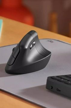 a computer mouse sitting on top of a desk next to a keyboard and mouse pad