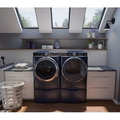 a washer and dryer in a room with skylights on the windows above