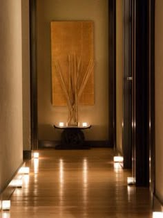 an empty hallway with lights on the floor and a painting in the corner behind it