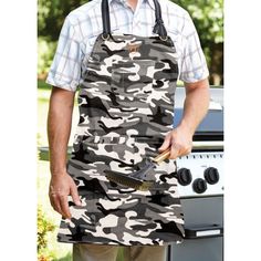 a man wearing an apron and holding a spatula in front of a bbq