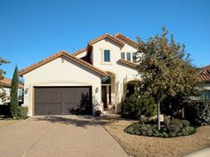 a large house with two garages in front of it