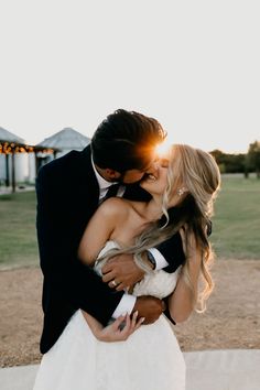 a bride and groom kissing in the sun