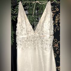 a white wedding dress hanging on a rack