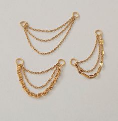 three different types of gold chains on a white surface