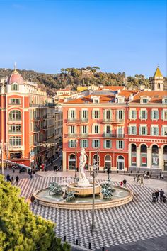 an aerial view of a city square with people walking around and buildings in the background