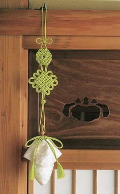 an animal paw is hanging from the side of a wooden door with a green string attached to it