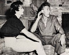 an old black and white photo of two women sitting on a couch talking to each other