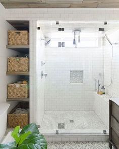 a bathroom with white tile and wood ceilinging, including a walk - in shower