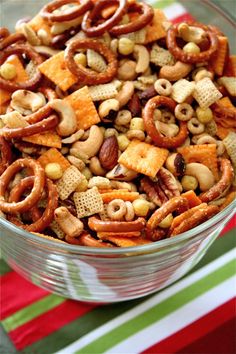 a bowl filled with cereal and pretzels on top of a striped table cloth