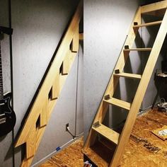 there are two wooden ladders in the room next to each other on the floor